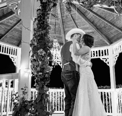 Bride and groom dancing. He is a cowboy